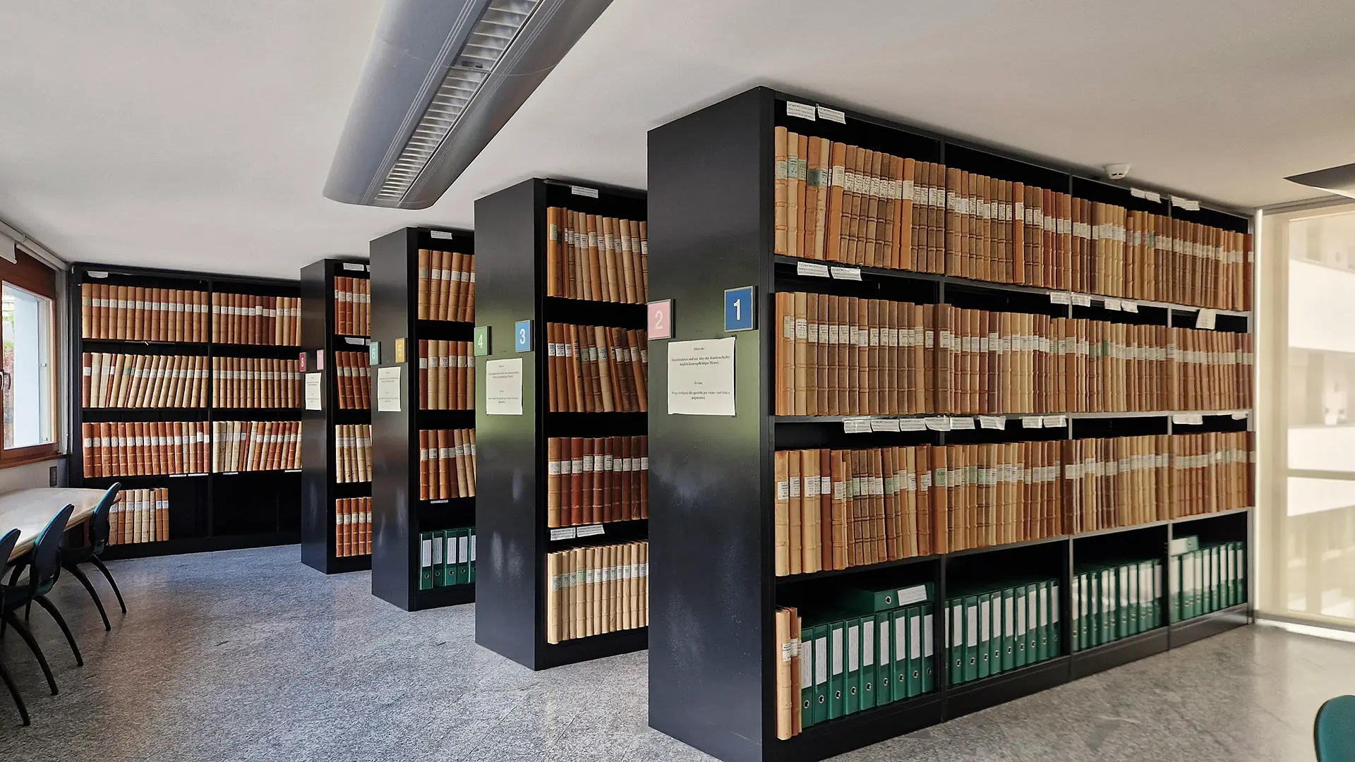 Rows of bound land registry volumes inside a South Tyrol Grundbuch (Libro Fondiario) office