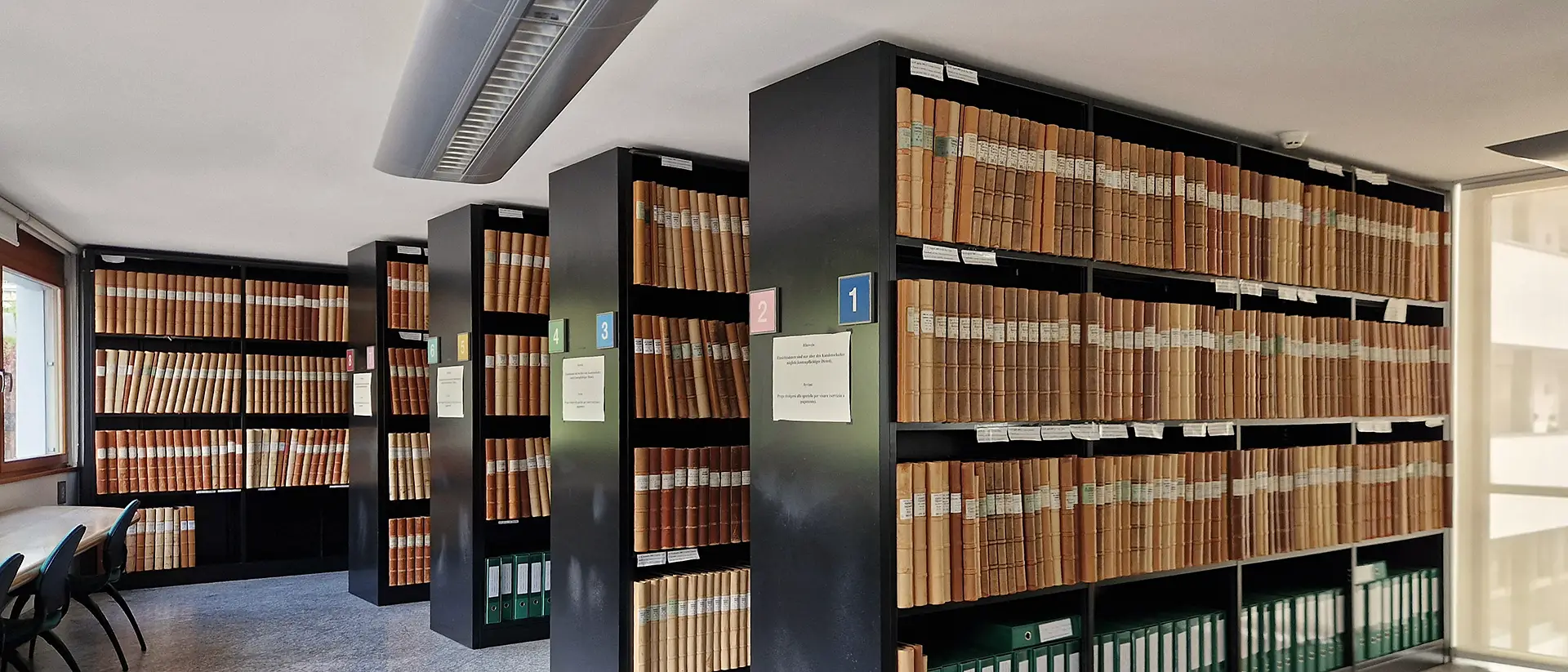 A long view of bound land registry volumes spanning many decades inside a South Tyrol Grundbuch office A long view of bound land registry volumes spanning many decades inside a South Tyrol Grundbuch office